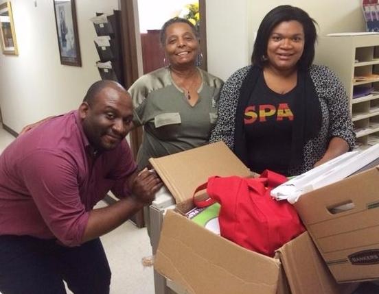 OPC's Kenneth Mallory and Linda Jefferson deliver school supplies to Metropolitan AME Church's Katrina Holiday that OPC staff donated. The church is OPC's neighbor in downtown DC